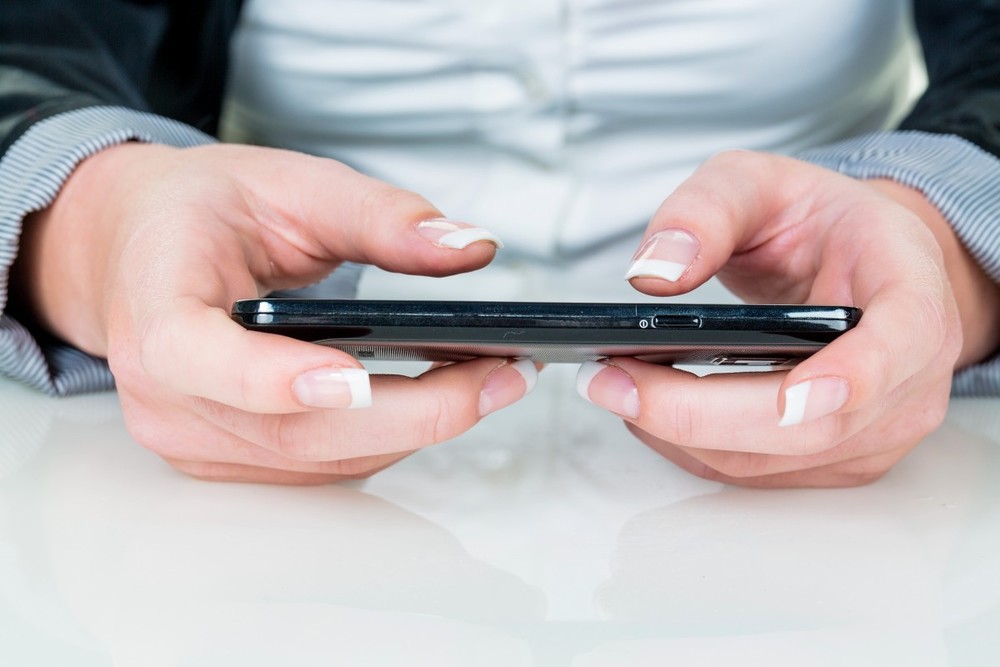 Eine Frau schreibt auf einem Smartphone / bilderbox.com / Erwin Wodicka Katholische Publizisten begrüßen medienpolitische Regierungspläne