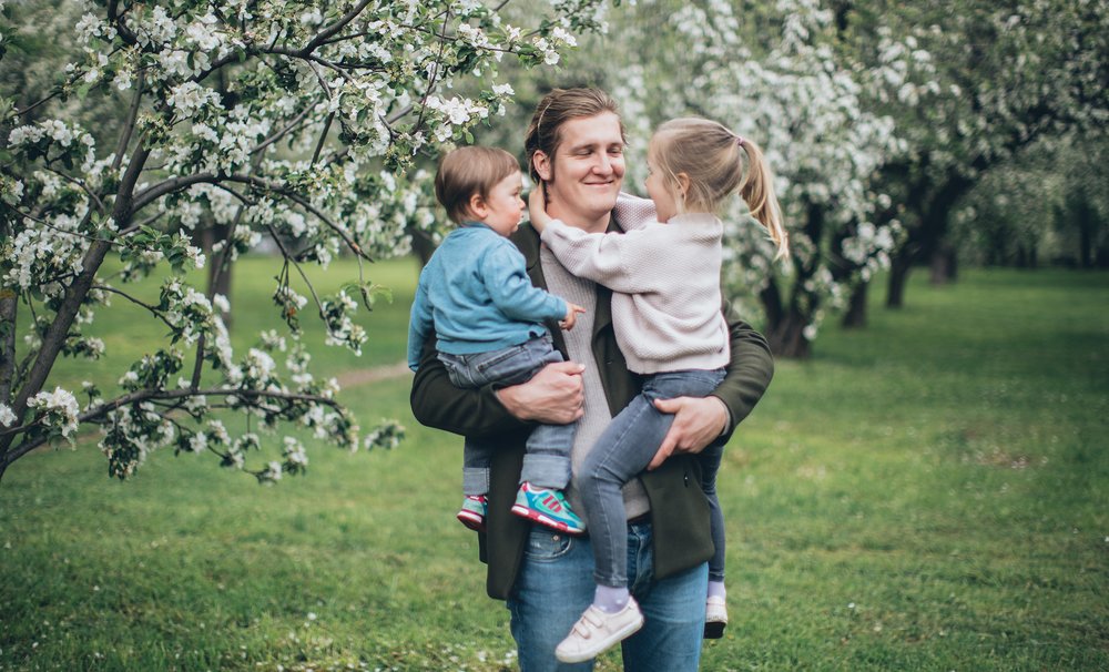 Vater mit zwei Kindern im Arm / pexels.com / Elina Fairytale Vater mit zwei Kindern im Arm