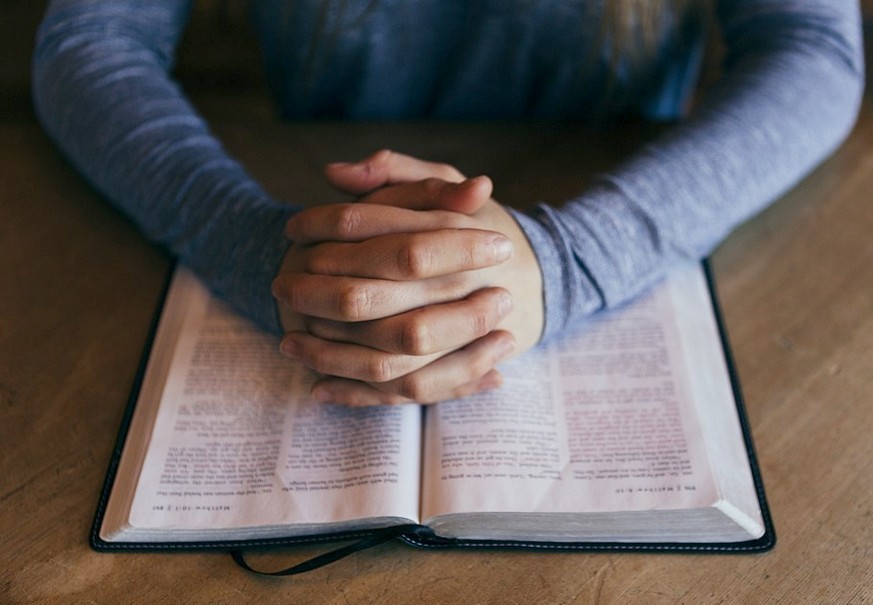 Betende Hände über der Bibel / pixabay / gemeinfrei Theologin: 'Bibel ist Gegenpol zu Negativschlagzeilen'